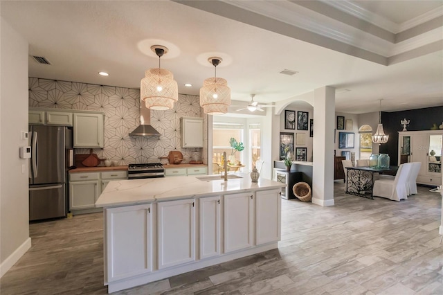 kitchen with ceiling fan with notable chandelier, sink, stainless steel appliances, and hanging light fixtures