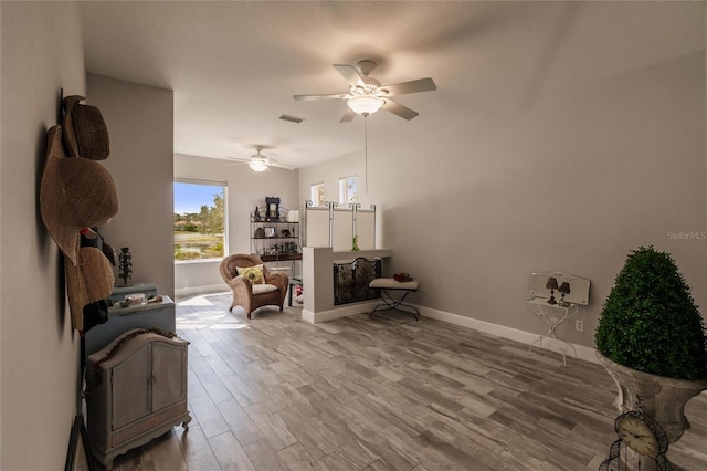 sitting room with light wood-type flooring and ceiling fan