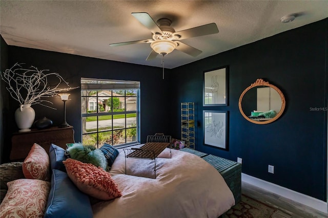 bedroom with hardwood / wood-style floors, ceiling fan, and a textured ceiling