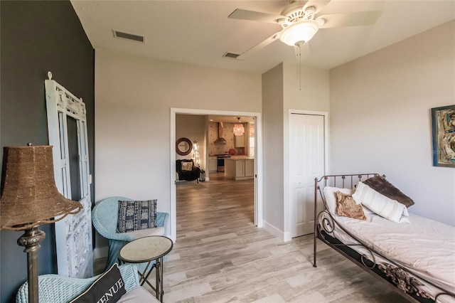 living area with light hardwood / wood-style flooring and ceiling fan