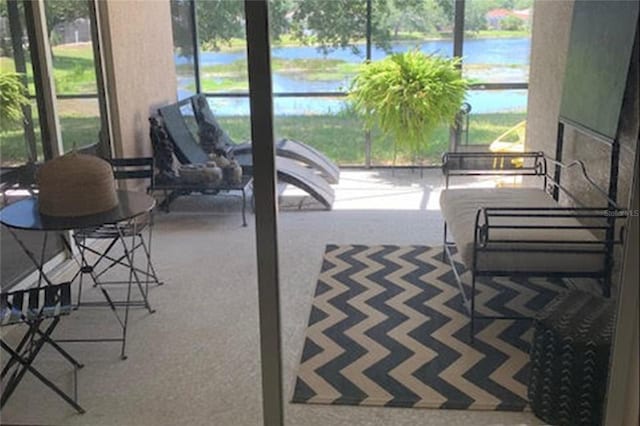 sunroom / solarium featuring a water view and a wealth of natural light