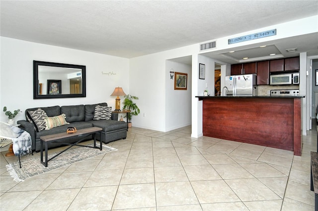 tiled living room featuring a textured ceiling