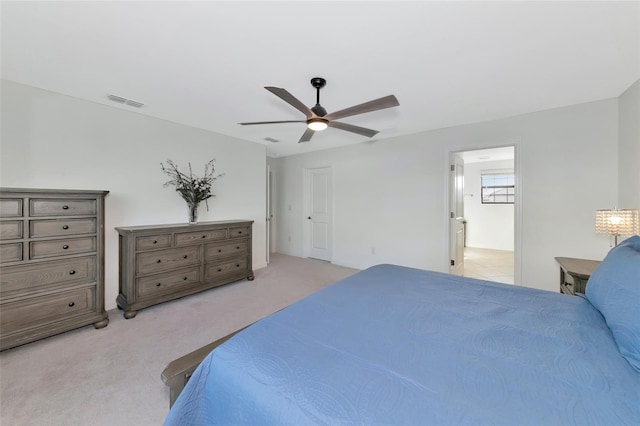 bedroom featuring ceiling fan, connected bathroom, and light carpet