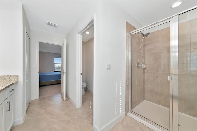 bathroom featuring vanity, toilet, tile patterned flooring, and walk in shower