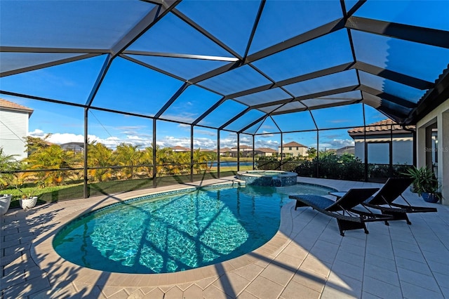 view of pool with a patio area, glass enclosure, and an in ground hot tub