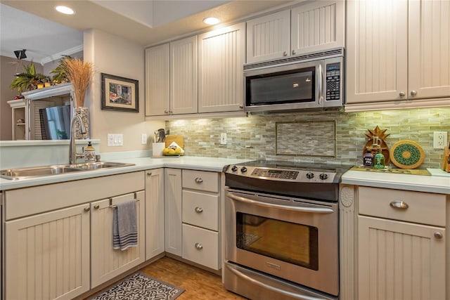 kitchen featuring sink, backsplash, light hardwood / wood-style flooring, and stainless steel appliances