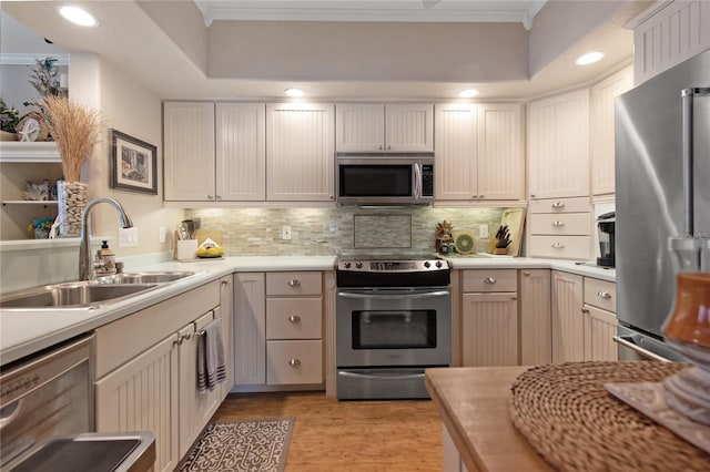 kitchen with tasteful backsplash, sink, ornamental molding, and stainless steel appliances