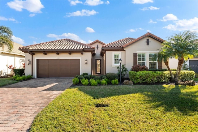 mediterranean / spanish home featuring a front yard and a garage