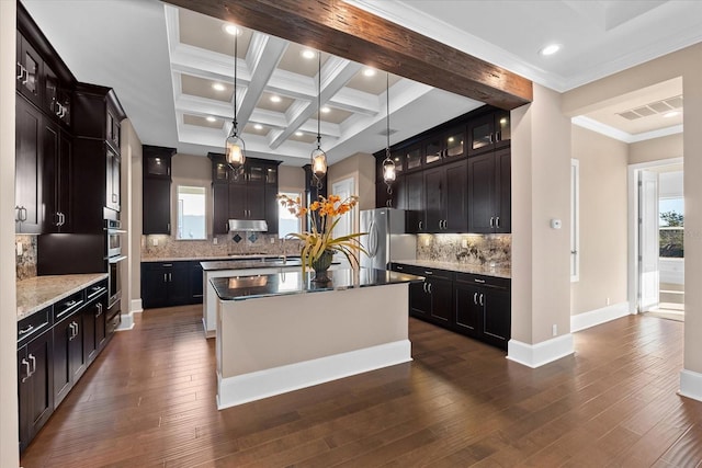 kitchen with stainless steel fridge, backsplash, dark hardwood / wood-style floors, and a kitchen island