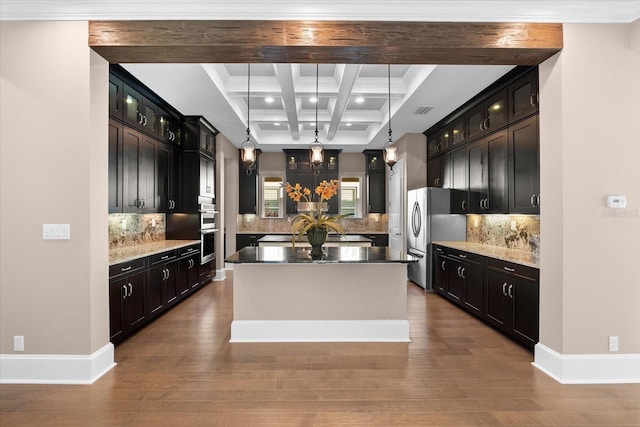 kitchen with beam ceiling, tasteful backsplash, a kitchen island, and hanging light fixtures