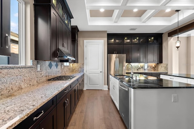 kitchen featuring hardwood / wood-style floors, dark stone counters, sink, decorative light fixtures, and stainless steel appliances