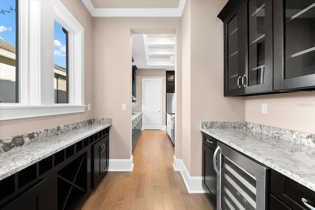 kitchen featuring light stone countertops, light hardwood / wood-style floors, wine cooler, and ornamental molding