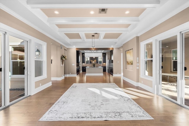 hallway with beam ceiling, light wood-type flooring, ornamental molding, and coffered ceiling