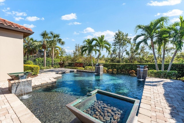 view of pool featuring pool water feature, a patio area, and an in ground hot tub