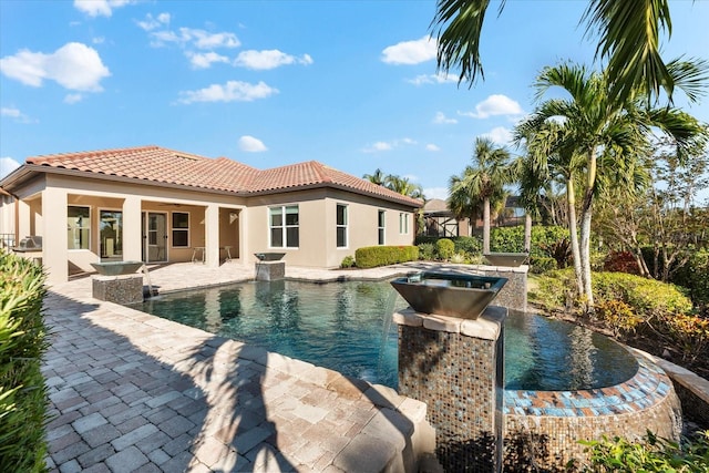 view of swimming pool featuring a jacuzzi and a patio