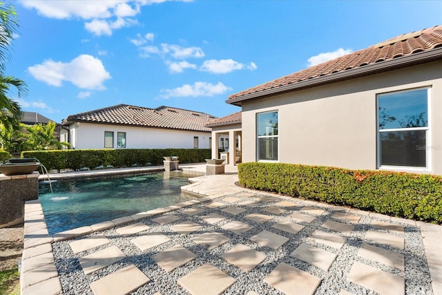 view of swimming pool featuring pool water feature and a patio