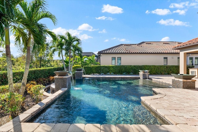 view of swimming pool with pool water feature and a patio