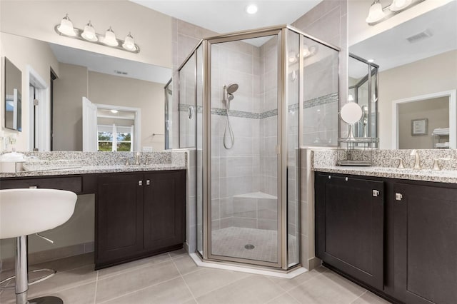 bathroom with walk in shower, tile patterned floors, and vanity