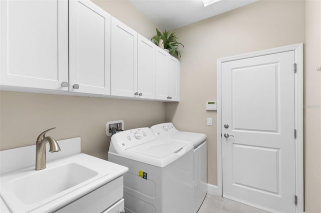 laundry area featuring independent washer and dryer, cabinets, sink, and light tile patterned floors