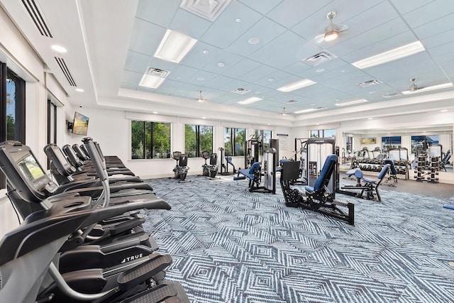 workout area featuring a raised ceiling, carpet floors, and a drop ceiling