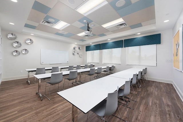 interior space with a raised ceiling and dark hardwood / wood-style floors