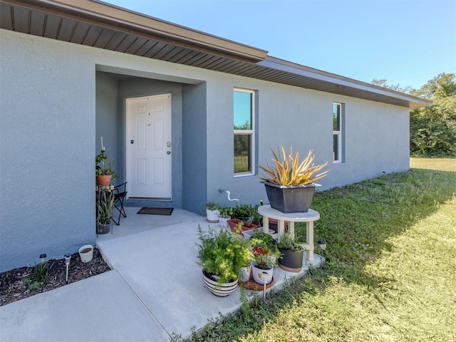 entrance to property with a lawn