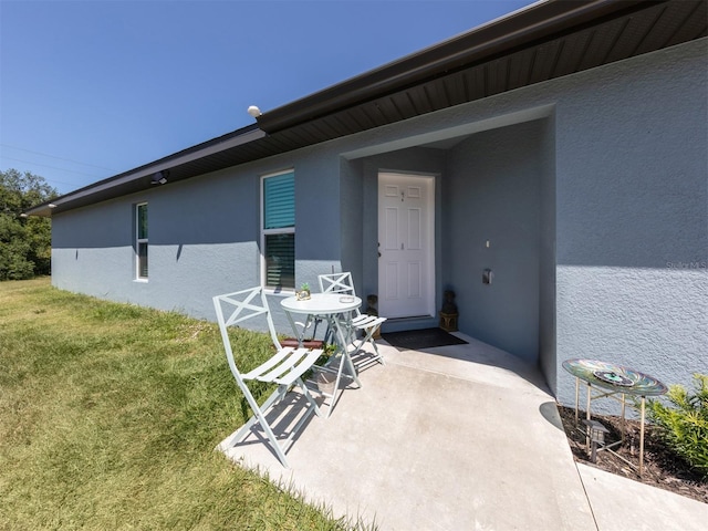 doorway to property with a lawn