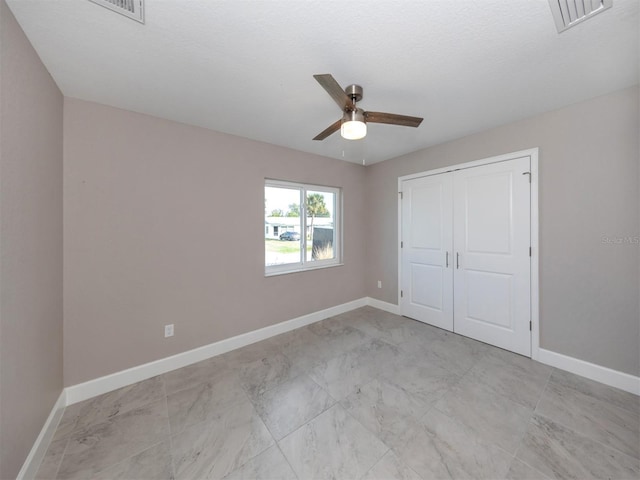 unfurnished bedroom featuring ceiling fan, a closet, and a textured ceiling