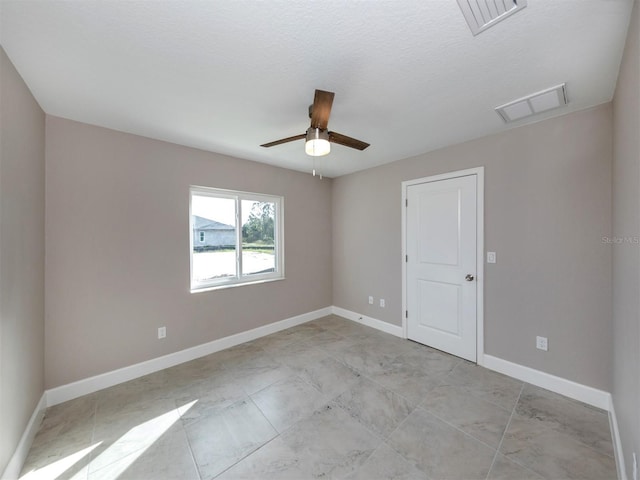 spare room with ceiling fan and a textured ceiling