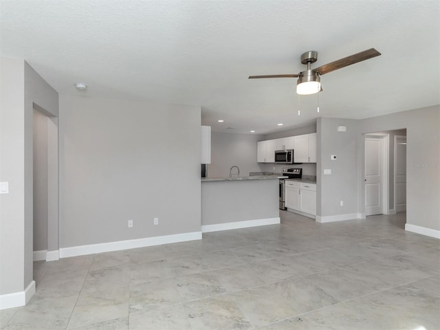 unfurnished living room featuring ceiling fan, sink, and a textured ceiling