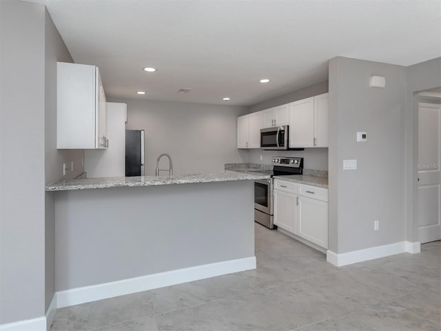 kitchen with kitchen peninsula, white cabinetry, and appliances with stainless steel finishes