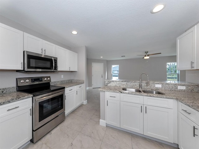 kitchen with white cabinetry, sink, stainless steel appliances, and a textured ceiling