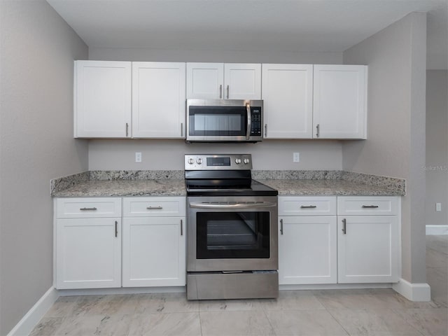 kitchen featuring light stone countertops, white cabinets, and stainless steel appliances