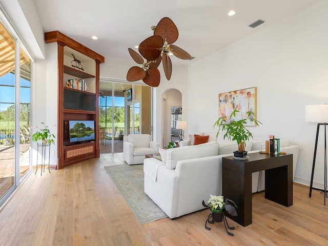 living room with light wood-type flooring and ceiling fan