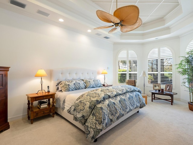 bedroom featuring light colored carpet, a raised ceiling, ceiling fan, and crown molding