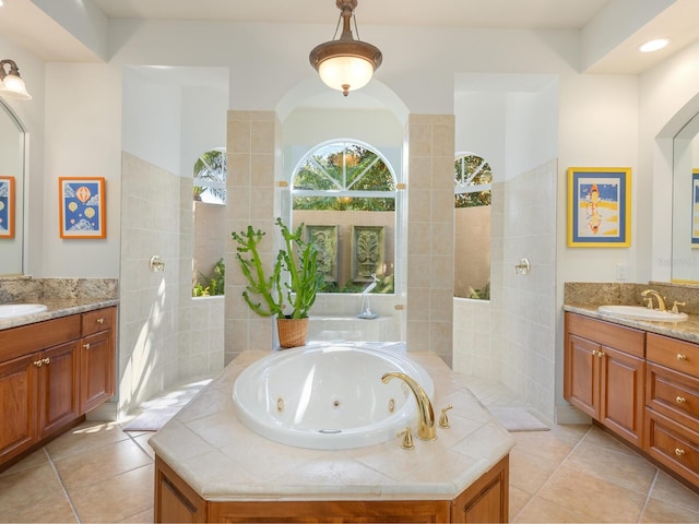 bathroom featuring vanity, a relaxing tiled tub, and tile patterned floors