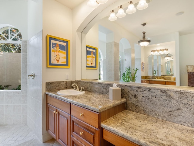 bathroom with vanity and tiled shower