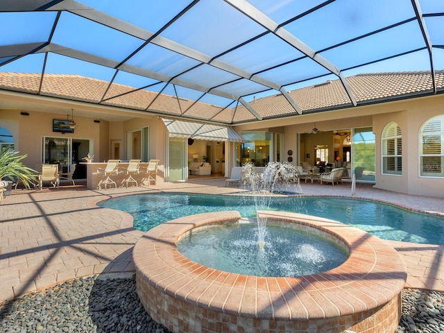 view of swimming pool with ceiling fan, an outdoor bar, pool water feature, a patio area, and an in ground hot tub