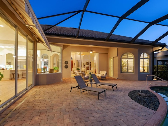 patio terrace at dusk with a lanai and ceiling fan