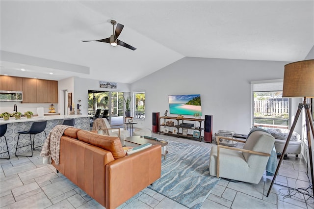 living room featuring a wealth of natural light, vaulted ceiling, and ceiling fan