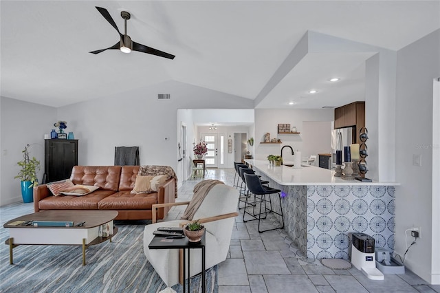 living room featuring ceiling fan, lofted ceiling, and sink