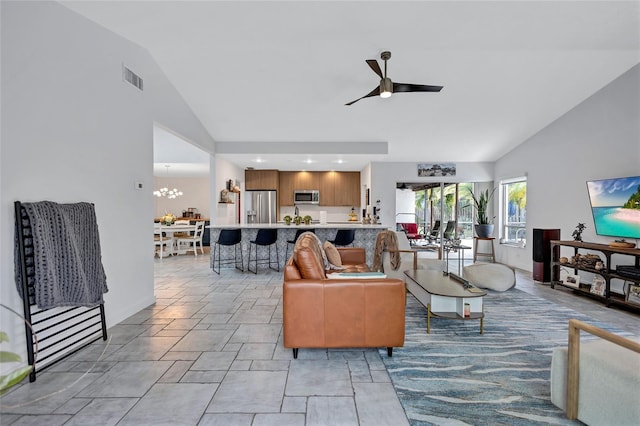 living room featuring ceiling fan with notable chandelier and lofted ceiling