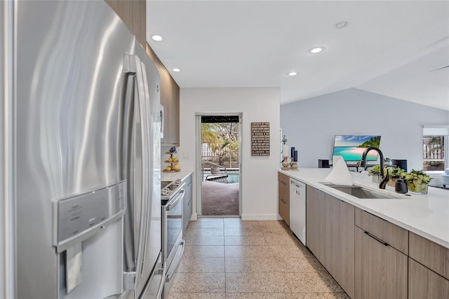 kitchen featuring sink, stainless steel appliances, and vaulted ceiling