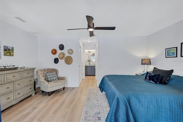 bedroom featuring light wood-type flooring, ensuite bath, and ceiling fan