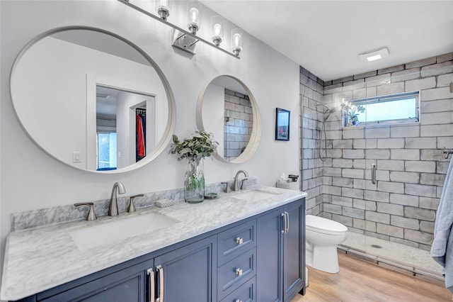 bathroom with hardwood / wood-style floors, vanity, toilet, and walk in shower