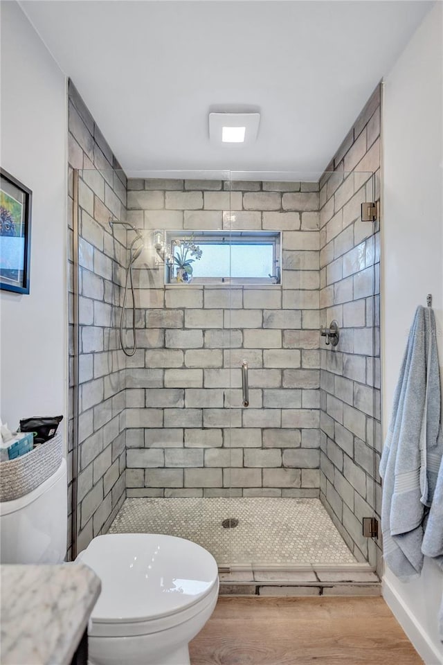 bathroom featuring hardwood / wood-style flooring, vanity, toilet, and a shower with door