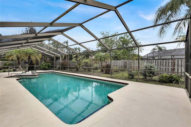 view of pool featuring glass enclosure and a patio area