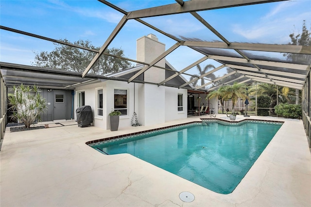 view of swimming pool featuring area for grilling, a patio area, and a lanai