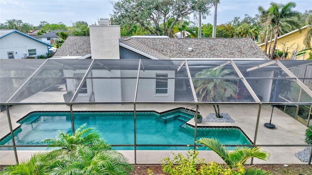 view of pool featuring glass enclosure and a patio