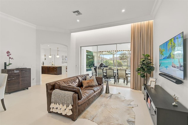 living room featuring an inviting chandelier, crown molding, and sink